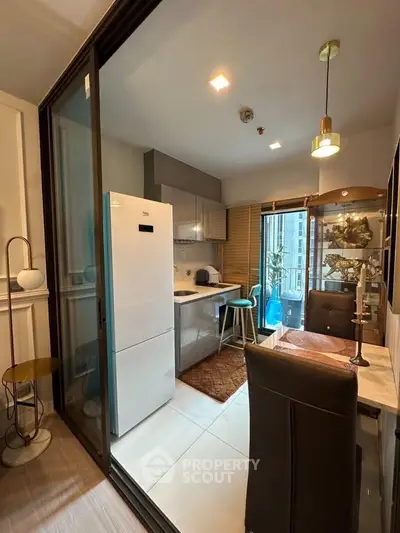 Modern kitchen with open layout and stylish dining area in a cozy apartment.