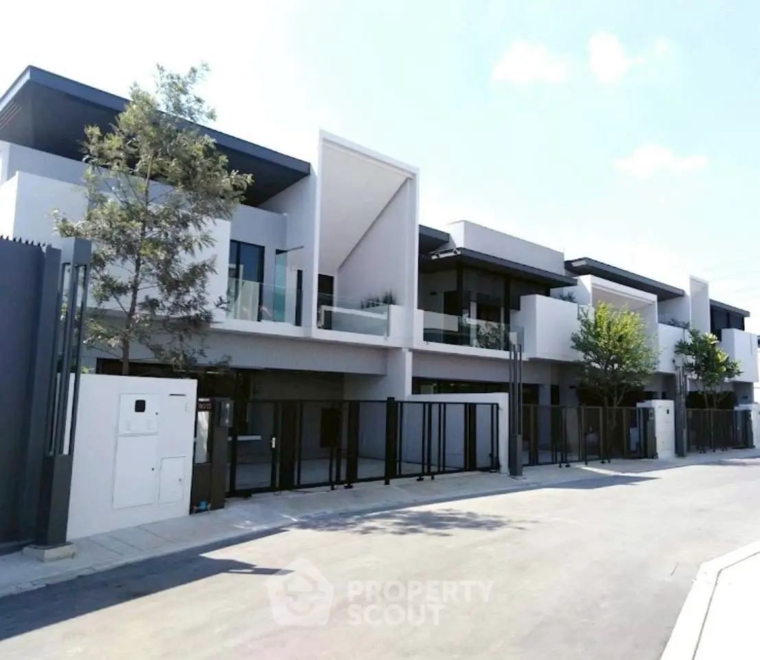 Modern architectural townhouse exterior with sleek design and spacious balconies.