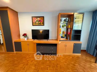 Spacious living room with elegant wooden cabinetry and modern TV setup