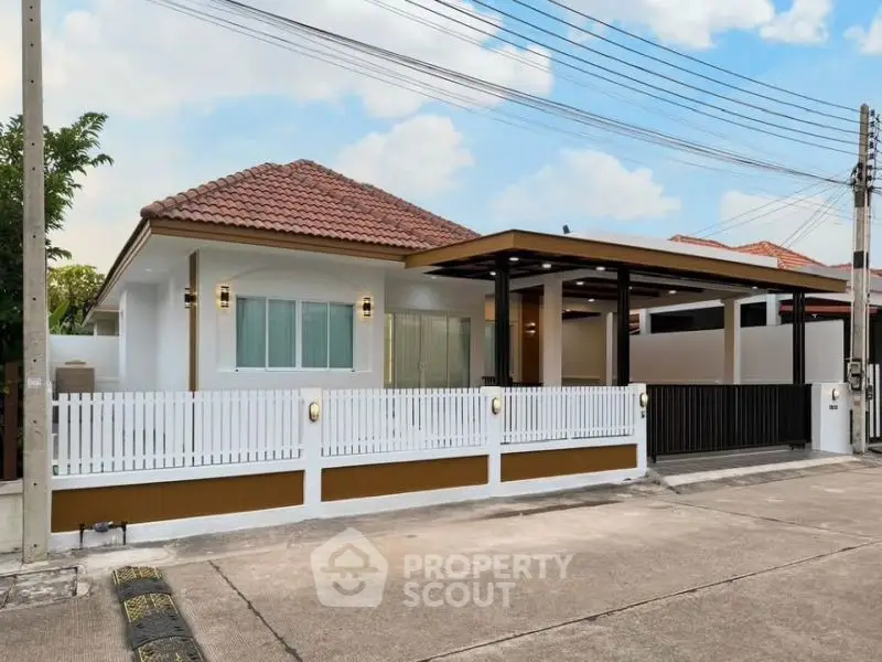 Charming single-story home with red-tiled roof and modern fence in a serene neighborhood.