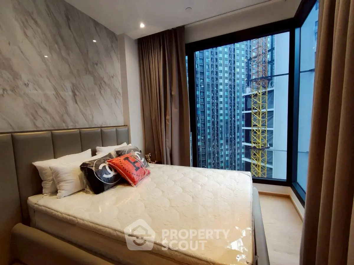 Luxurious bedroom with city view and modern decor in high-rise apartment
