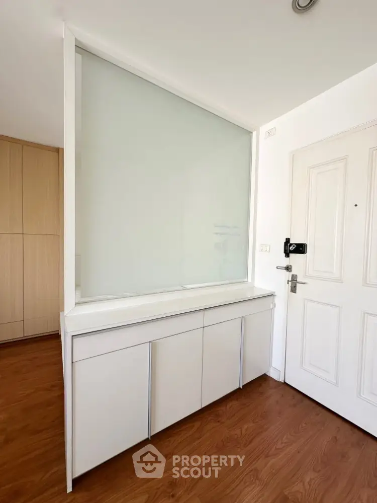 Modern interior with wooden flooring and sleek white cabinetry