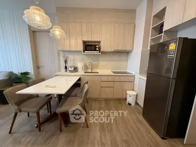 Modern kitchen with sleek cabinetry and dining area in stylish apartment.
