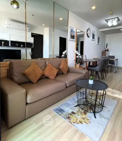 Modern living room with stylish decor and open layout, featuring a cozy sofa and elegant dining area.