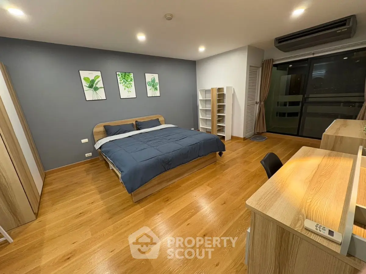 Spacious modern bedroom with wooden flooring and stylish decor