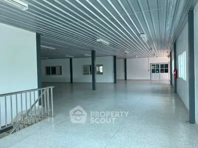 Spacious industrial-style interior with metal ceiling and open floor plan, ideal for commercial use.
