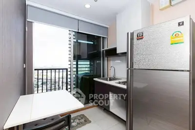 Modern kitchen with balcony view, featuring sleek appliances and ample natural light.