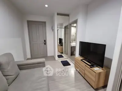 Modern living room with sleek TV setup and comfortable seating in a stylish apartment.
