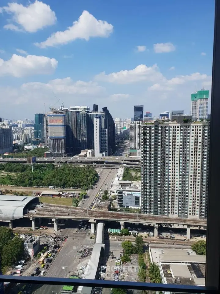 Stunning cityscape view from high-rise building window, showcasing urban skyline and blue sky.