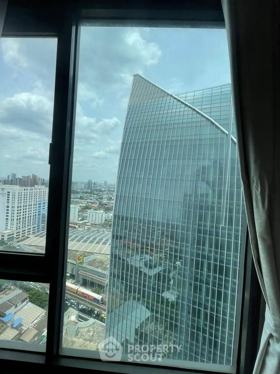 Stunning cityscape view from high-rise window showcasing modern architecture and urban skyline.
