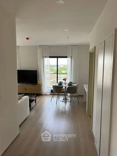 Bright modern living room with dining area and large window view.