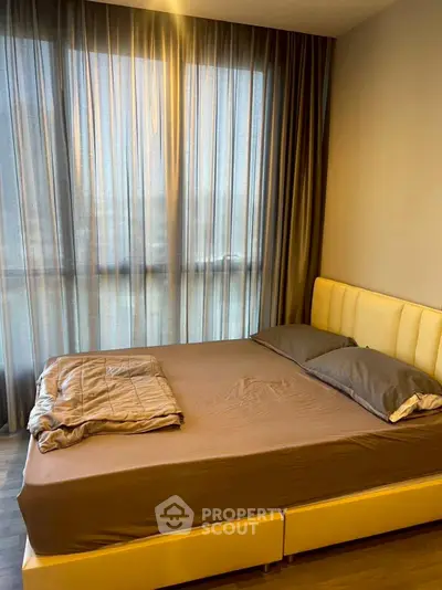 Modern bedroom with large window and stylish bed in cozy apartment.