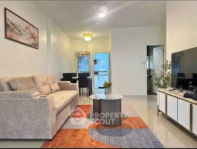 Modern living room with stylish decor and open layout, featuring a cozy sofa and elegant dining area.