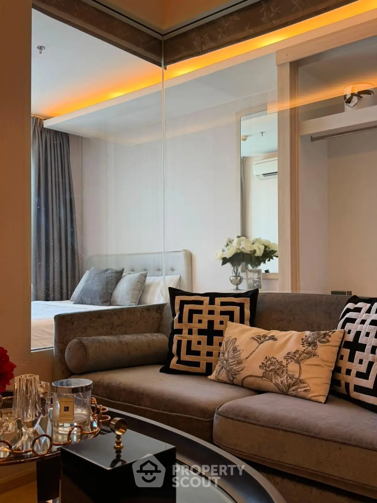 Luxurious modern living room with elegant decor and glass partition to bedroom