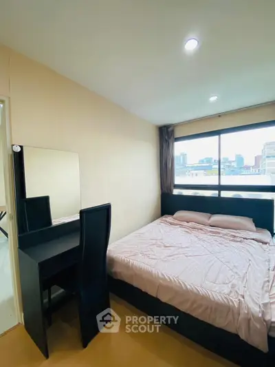 Cozy bedroom with city view, featuring a comfortable bed and sleek vanity desk, perfect for urban living.