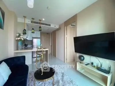 Modern living room with open kitchen, stylish decor, and cozy seating area in a contemporary apartment.