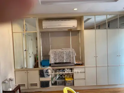 Spacious living room with built-in storage and air conditioning unit, perfect for organized living.