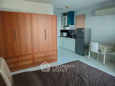 Cozy studio apartment with modern kitchen and dining area, featuring ample storage and air conditioning.