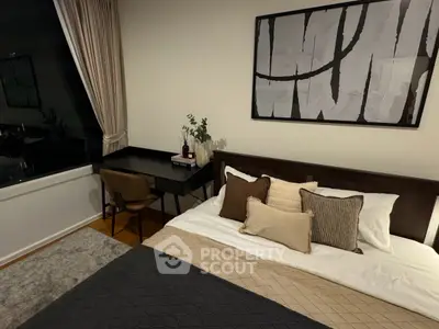 Modern bedroom with stylish decor and large window offering natural light.
