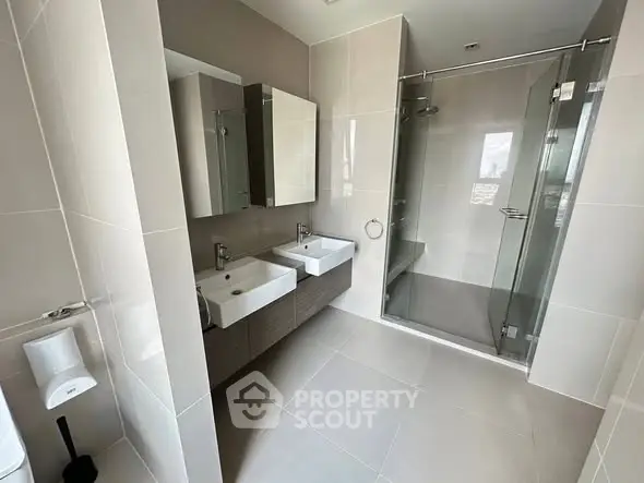 Modern bathroom with dual sinks and glass shower enclosure