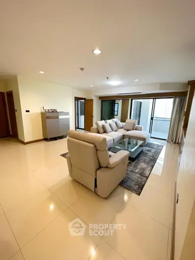 Spacious modern living room with elegant furnishings and large windows for natural light.