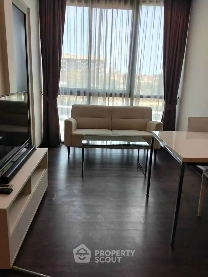 Modern living room with large windows and stylish furniture in a bright apartment.