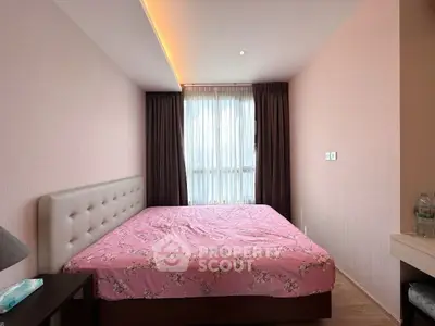 Cozy bedroom with pink floral bedding and modern decor, featuring a large window with elegant curtains.
