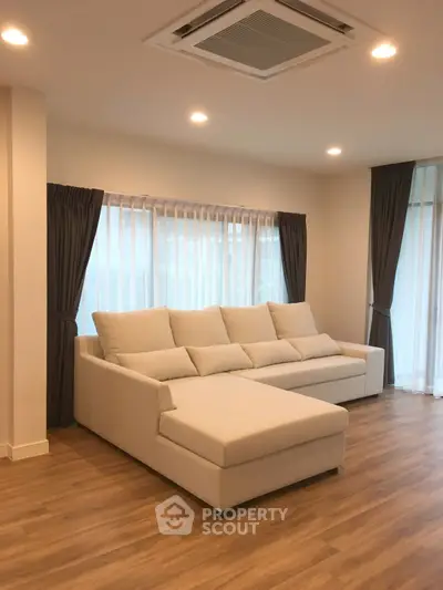 Spacious living room with elegant sofa and large windows