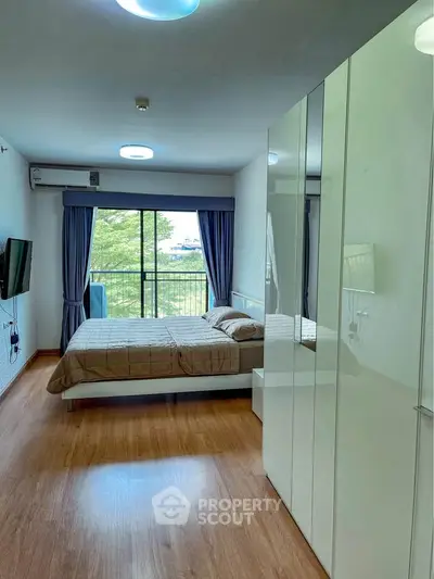 Modern bedroom with large window and stylish decor, perfect for relaxation.