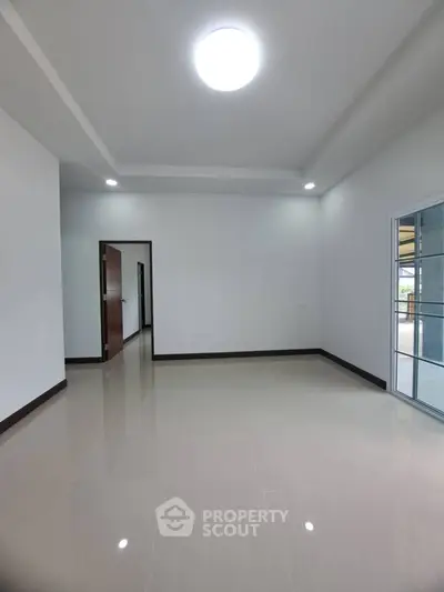 Spacious empty room with glossy tiled floor and bright lighting, ideal for customization.