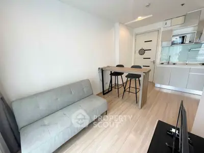 Modern open-layout living room with sleek kitchen and stylish bar seating.