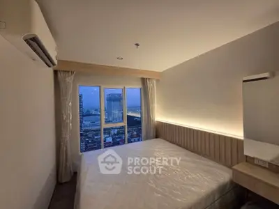 Modern bedroom with city view, featuring large window and ambient lighting.