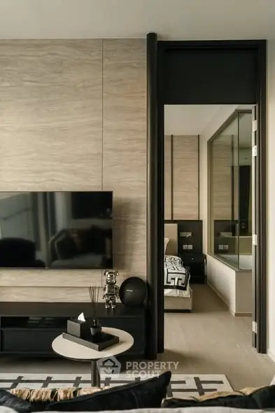 Modern living room with sleek TV setup and view into stylish bedroom