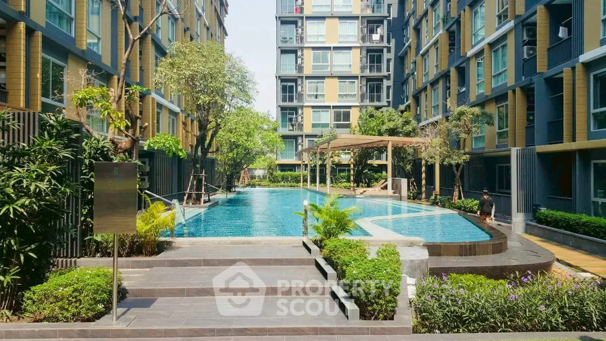 Modern apartment complex with lush greenery and inviting swimming pool