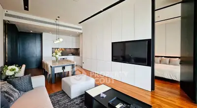 Modern open-plan living room with sleek kitchen and cozy dining area, featuring elegant decor and natural light.