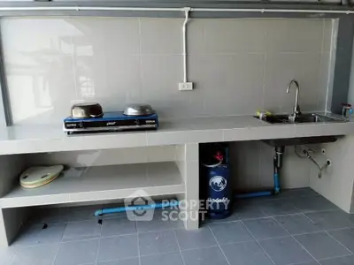 Modern kitchen with gas stove and sink in sleek tiled design