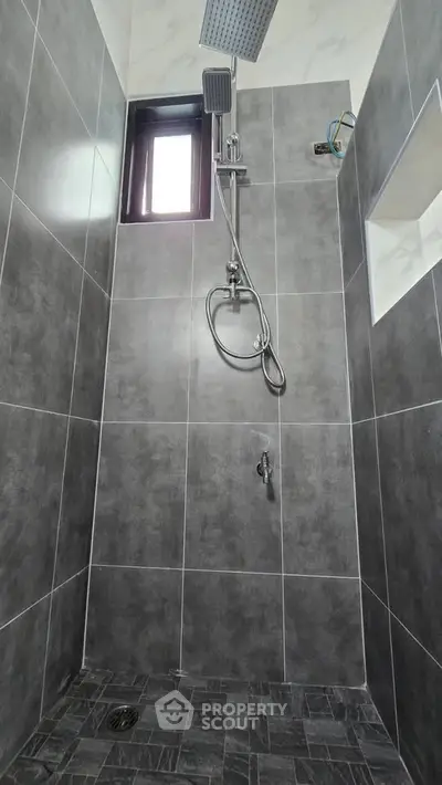Modern shower with sleek gray tiles and rainfall showerhead
