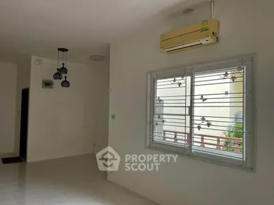 Spacious living room with air conditioning and modern lighting fixtures.