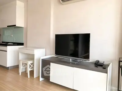 Modern living room with sleek TV stand and compact kitchen area