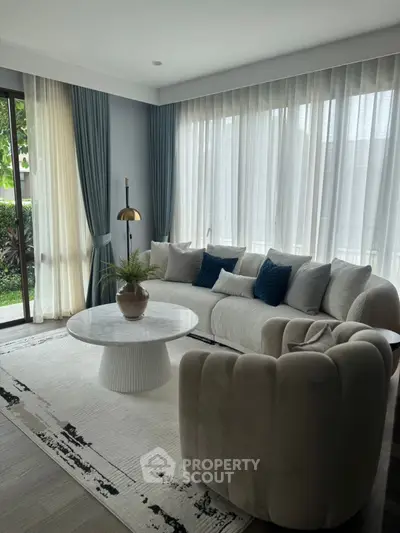 Elegant living room with modern furniture and large windows offering natural light