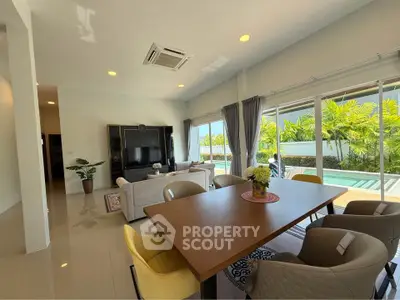 Spacious living room with pool view, modern furniture, and abundant natural light in a luxury home.