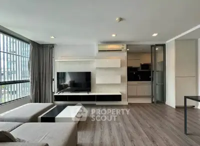 Modern living room with sleek design and open kitchen layout in a high-rise apartment.