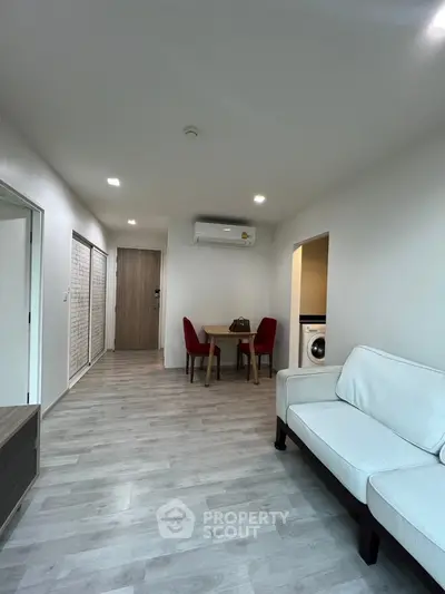 Modern living room with dining area and washing machine in open layout apartment