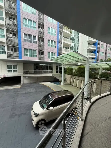 Modern apartment building exterior with parking area and stylish entrance.