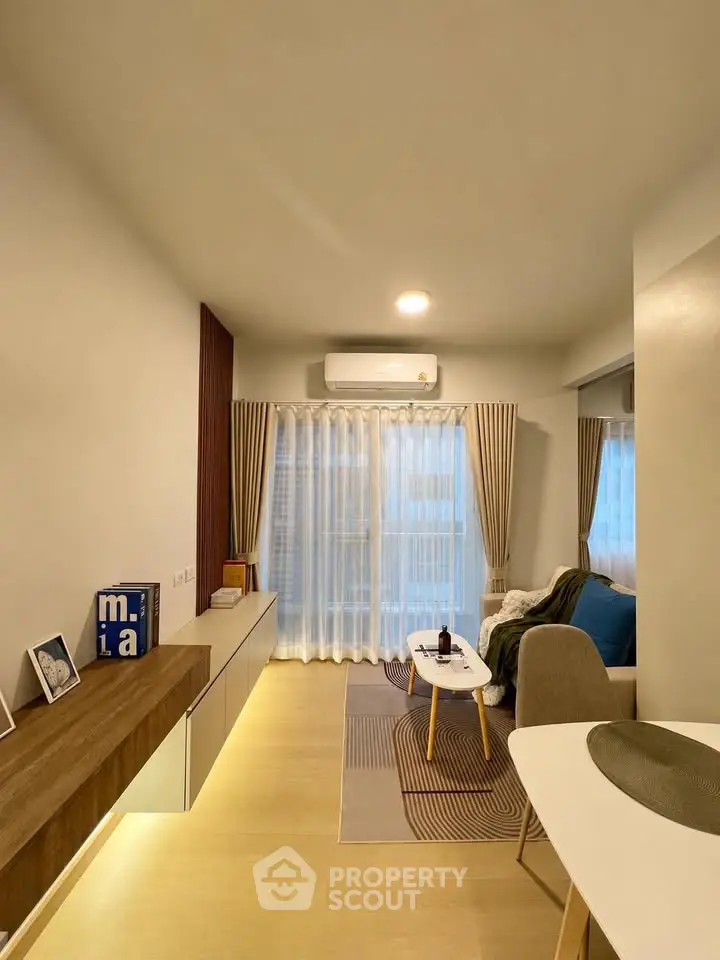 Modern living room with stylish decor and natural light, featuring a cozy seating area and elegant curtains.