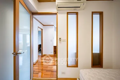 Modern bedroom with wooden accents and air conditioning unit
