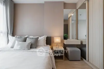 Modern bedroom with stylish decor and natural light, featuring a cozy bed and elegant furnishings.