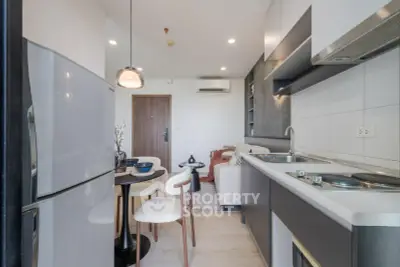 Modern open-layout kitchen and living area with sleek appliances and stylish decor.