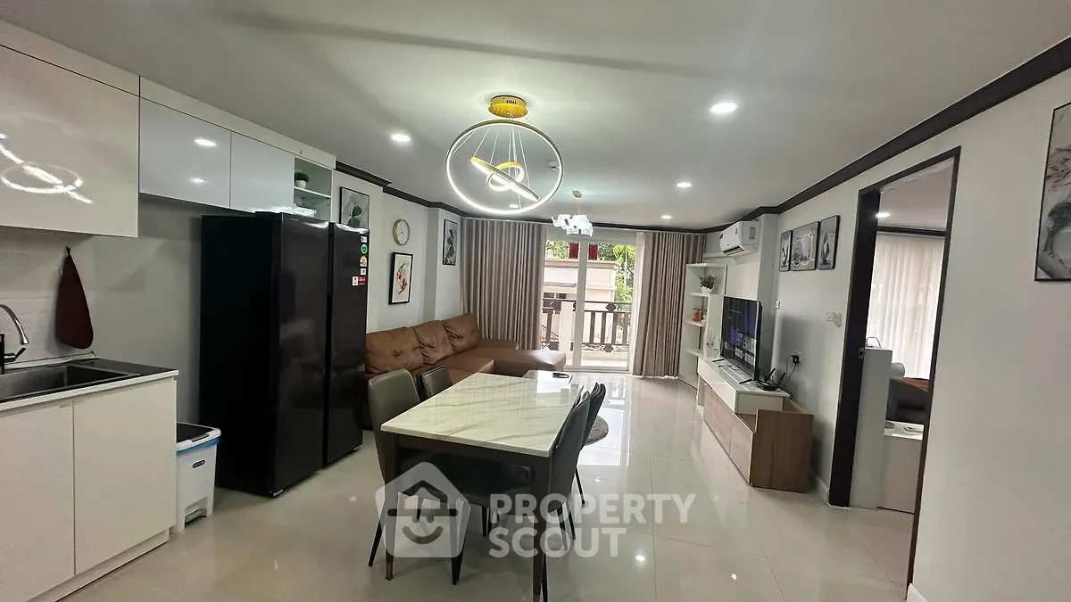 Modern open-plan living room and kitchen with stylish decor and ample natural light.