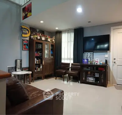 Stylish living room with modern decor, leather seating, and entertainment setup.